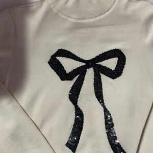 Cream colored with Black sequined Bow light weight sweater Large
New York & Co
